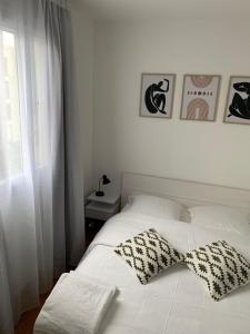 - un lit blanc avec 2 oreillers dans l'établissement Chambre Privée Face arrêt de Tram proche métro 5 Pablo Picasso, Chambres individuelles , La cuisine , le WC et la salle de bain sont en commun, à Bobigny