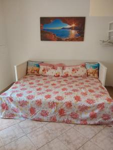 una cama con un edredón floral encima en Nonna Libera monolocale, en Rodi Garganico