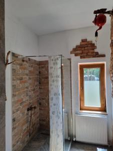 a bathroom with a brick wall and a window at Viewtopia The Secret Land in Valea Drăganului