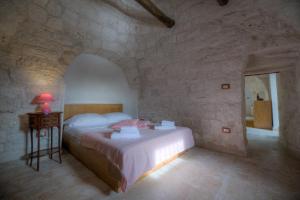 una camera con un letto in una parete in pietra di Trullo Casa Surya a Martina Franca