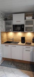 cocina con armarios blancos y encimera en Gemütliches Ferienhaus Bungalow SixtyTwo in Dipperz-Dörmbach en Dipperz