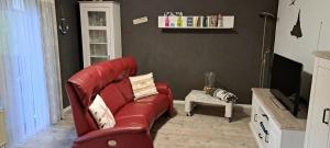 a living room with a red couch and a tv at Gemütliches Ferienhaus Bungalow SixtyTwo in Dipperz-Dörmbach in Dipperz