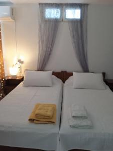 Agia Marina MikrolimanouにあるPRIVATE SEASIDE GUEST HOUSE...のタオルが敷かれたベッドが2つある寝室 +37枚の写真
