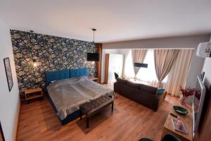1 dormitorio con 1 cama y 1 sofá en una habitación en Апартамент за гости Асеновец en Asenovgrad