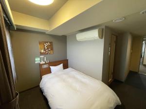 三沢市にあるホテルルートイン三沢のベッドルーム1室(白いベッド1台付)