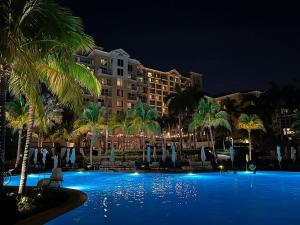 uma piscina com palmeiras e um hotel à noite em Studio Located at The Ritz Carlton Key Biscayne, Miami em Miami