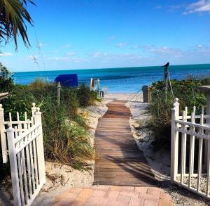 - un sentier en bois menant à la plage avec un oiseau dans l'établissement Studio Located at The Ritz Carlton Key Biscayne, Miami, à Miami