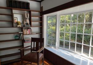 uma cadeira sentada ao lado de uma janela num quarto em Storybook Lake Front Villa with Private Beach! em Winchester