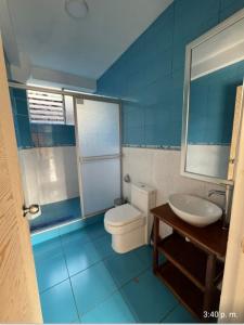 Baño azul con aseo y lavamanos en Illawasi Lofts en Urubamba