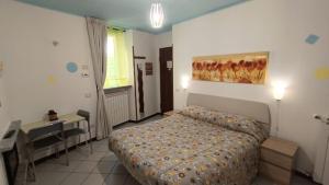 1 dormitorio con cama, escritorio y escritorio en Guesthouse Serena, en Stresa