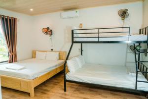 a room with two bunk beds and a window at Tran Chau Garden Home in Cat Ba
