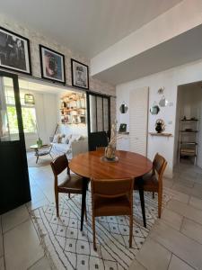a living room with a wooden table and chairs at Le grand abri de la Garenne - Séjour cosy à Blois in Blois