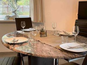 una mesa con copas de vino y platos en ella en Ferienwohnung Schweizer Sennenhund en Nauders