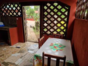 una mesa y sillas en una habitación con puerta en Bungalow chez Mouch Nosy-Be 3, en Nosy Be
