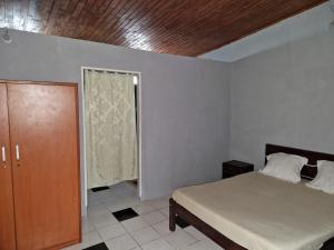 Un dormitorio con una cama y un techo de madera. en Bungalow chez Mouch Nosy-Be 3, en Nosy Be
