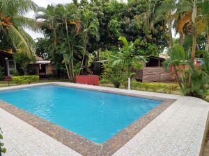 una piscina en un patio con árboles en Bungalow chez Mouch Nosy-Be 3, en Nosy Be