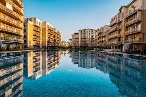 een groot zwembad met water in een stad met gebouwen bij Double Studio B105 StayInn by Cosmopolis in Creţuleasca