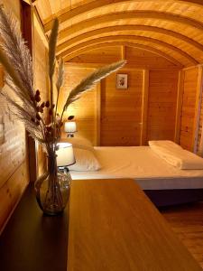 Lac des Rouges TruitesCamping-Chalets La Favière的卧室里有一张床，桌子上放着一瓶花