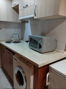 una cocina con microondas en una encimera junto a un fregadero en Balti house, en Bălţi