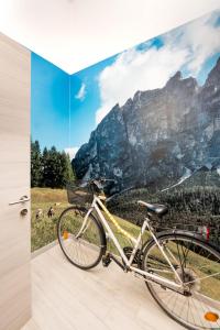 una bicicleta estacionada frente a una foto de una montaña en CityU - Grazioli 27 Trento Centro con parcheggio privato en Trento