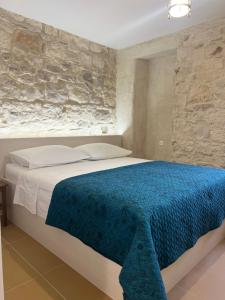 a bedroom with a large bed with a blue blanket at Sailor's apartment in Supetar