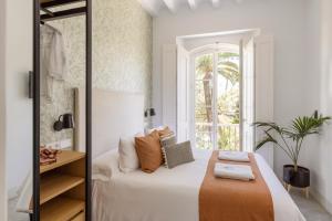 1 dormitorio con cama y ventana en Candelaria10, en Cádiz