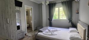 a bedroom with a bed and a large mirror at Hotel VEAL in Tepelenë