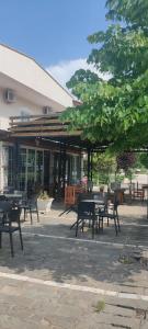 a group of tables and benches in front of a building at Hotel VEAL in Tepelenë