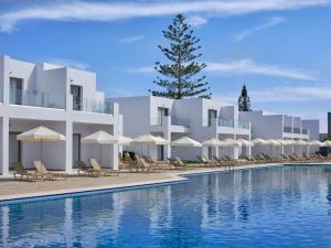 ein Hotel mit einem Pool mit Stühlen und Sonnenschirmen in der Unterkunft Atlantica Panthea Resort in Ayia Napa