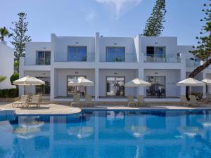 阿依納帕的住宿－Atlantica Panthea Resort，一座带游泳池和遮阳伞的大型白色建筑