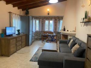 a living room with a couch and a tv at Villa Reni in Limenaria