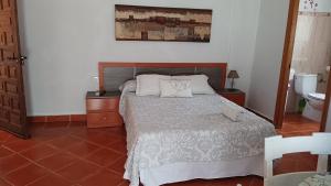 a bedroom with a bed with two pillows on it at Casa El Azahin in Cazalla de la Sierra