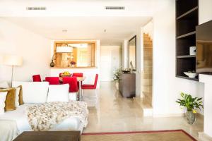 a living room with a white couch and red chairs at Comodo Triplex La Cala Golf in Mijas +31 photos