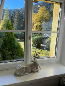 una estatua de un reno sentado en un alféizar de la ventana en Ferienwohung Husky en Nauders