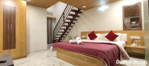 - une chambre avec un grand lit et un escalier dans l'établissement Woodland farm vila, à Mahabaleshwar