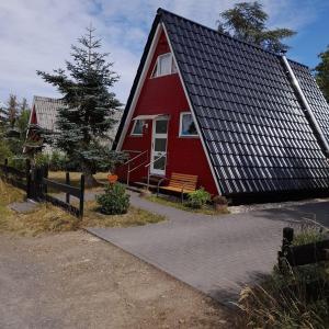 une maison rouge avec un banc devant elle dans l'établissement Eifeler Finnhaus mit Sauna Haus, à Dockweiler