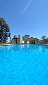 una gran piscina de agua azul con edificios al fondo en Bungalows Tiempo Libre en Colón