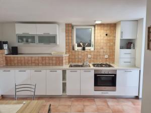 a kitchen with white cabinets and a sink at Sanda in Novi Vinodolski
