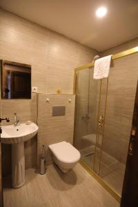 a bathroom with a shower and a toilet and a sink at Grand Uchisar Hotel in Uchisar