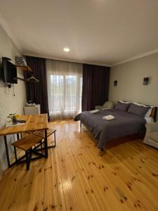 a bedroom with a bed and a wooden floor at Bibo's Kokhi Guesthouse in Stepantsminda