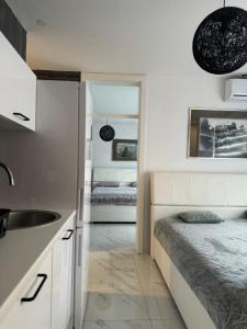 una cocina con fregadero y una cama en una habitación en Apartman City Center 2, en Prijedor