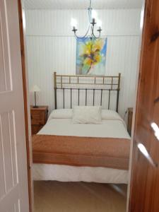 - une chambre avec un lit et une photo sur le mur dans l'établissement Apartamentos LA CASONA, à Jaraiz de la Vera