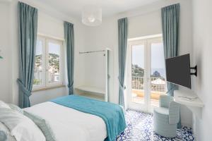 Casa Levante Luxury Apartments Capri في كابري: غرفه فندقيه بسرير ونافذه