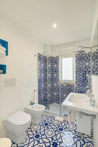 Casa Levante Luxury Apartments Capri في كابري: حمام مع مرحاض وحوض استحمام ومغسلة