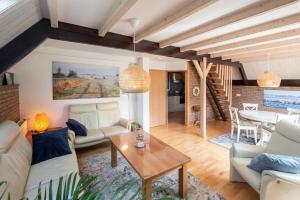 sala de estar con muebles blancos y mesa en Luxe 4p huis met SAUNA bij Grevelingenmeer!, en Herkingen
