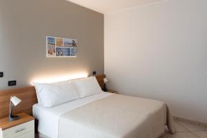 蒙特西爾瓦諾的住宿－Hotel D'Atri，一间卧室配有一张白色的床,床头灯上放着一盏灯