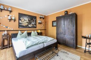 ein Schlafzimmer mit einem großen Bett und einem Holzschrank in der Unterkunft Ferienwohnung Kaffeetraum in Flensburg