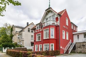 ein rotes Haus mit weißen Fenstern auf einer Straße in der Unterkunft Ferienwohnung Kaffeetraum in Flensburg