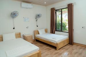 a bedroom with two beds and a window at Tran Chau Garden Home in Cat Ba +37 photos