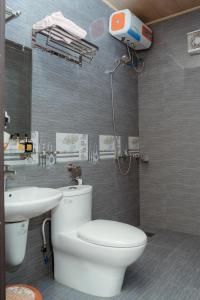 a bathroom with a white toilet and a sink at Tran Chau Garden Home in Cat Ba